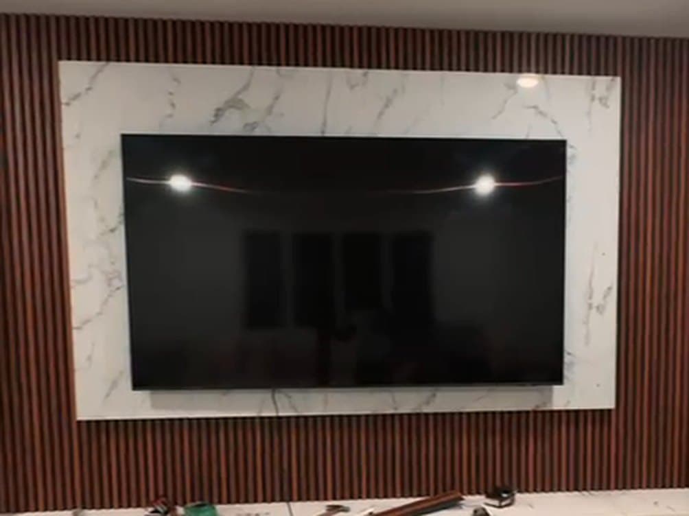 Mid-build: the same wall with the marble panel and slats up, before lighting and finishing
